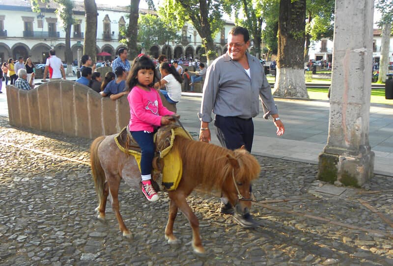 girl on pony in pretty Patzcuaro Mexico