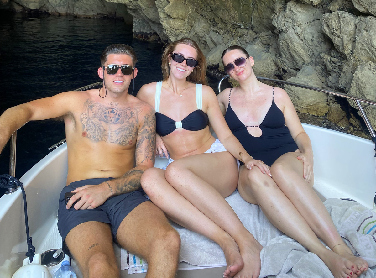 Three friends relaxing on a Garitransfer boat inside a sea cave on a Blue Cave tour from Dubrovnik